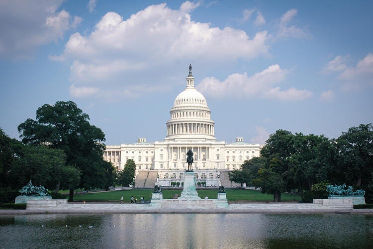 a white building with a dome and a fountain in front of it