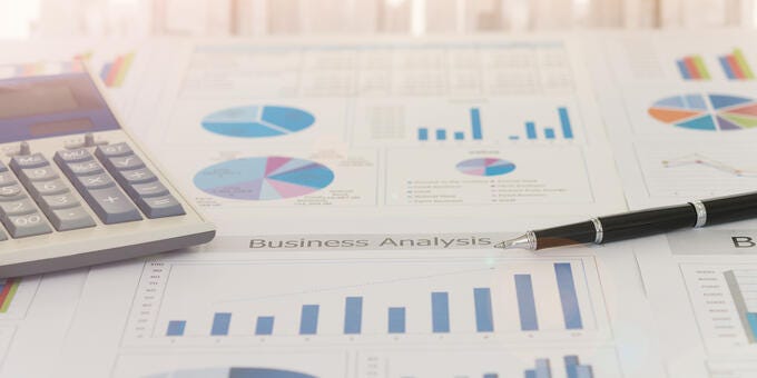 a close-up of a calculator and a pen on a paper