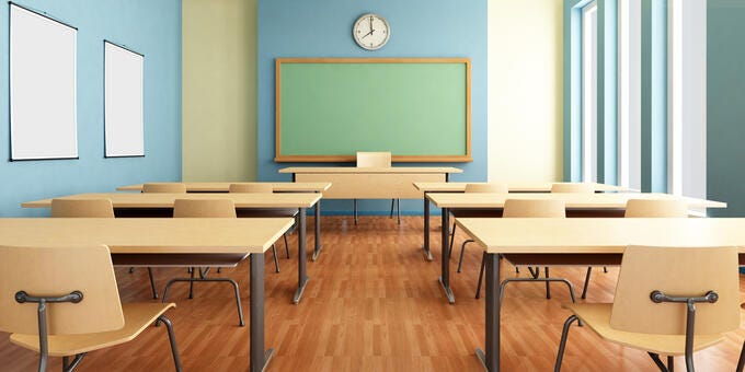 a classroom with desks and a large screen