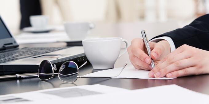 a person writing on a piece of paper