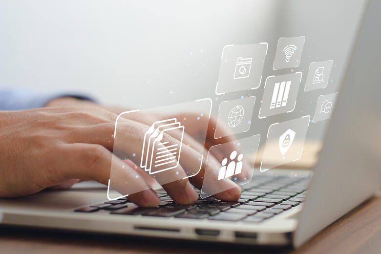 a close-up of hands typing on a laptop