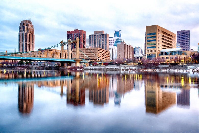 a city skyline with a bridge over a body of water