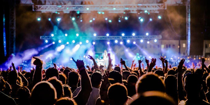a crowd of people in front of a stage with lights
