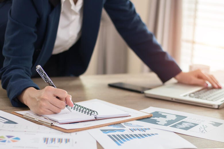 a person writing on a piece of paper