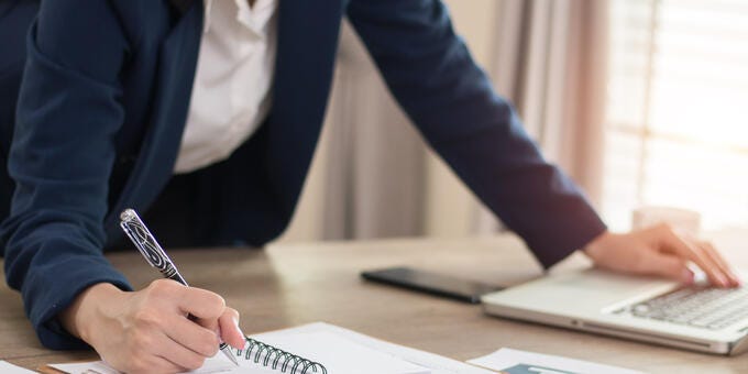 a person writing on a piece of paper