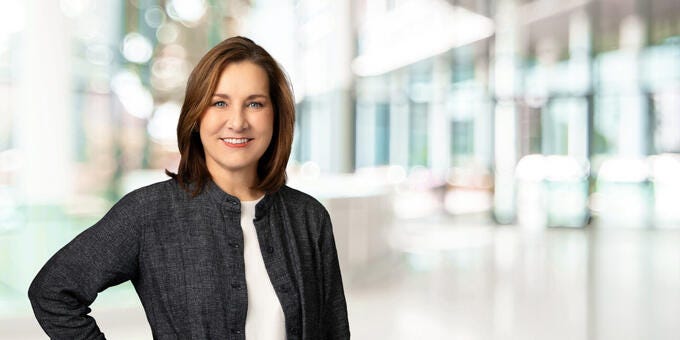 a woman smiling in a suit
