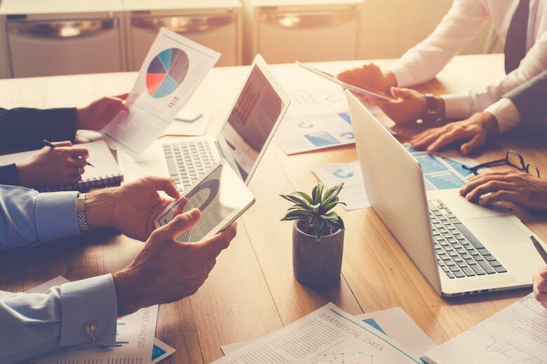 a group of people working on laptops